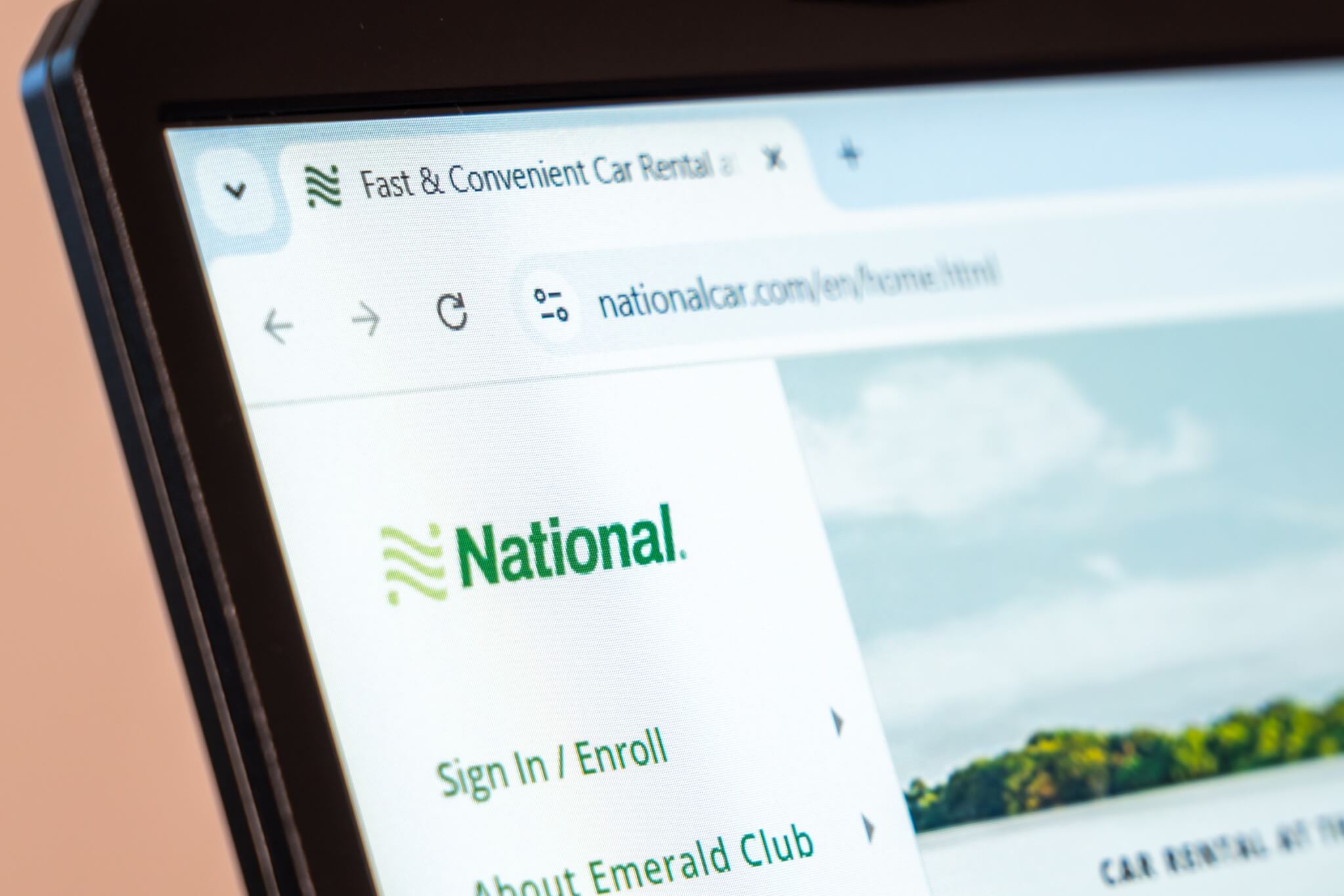  National Car Rental website homepage on laptop screen showcasing car rental services and loyalty program