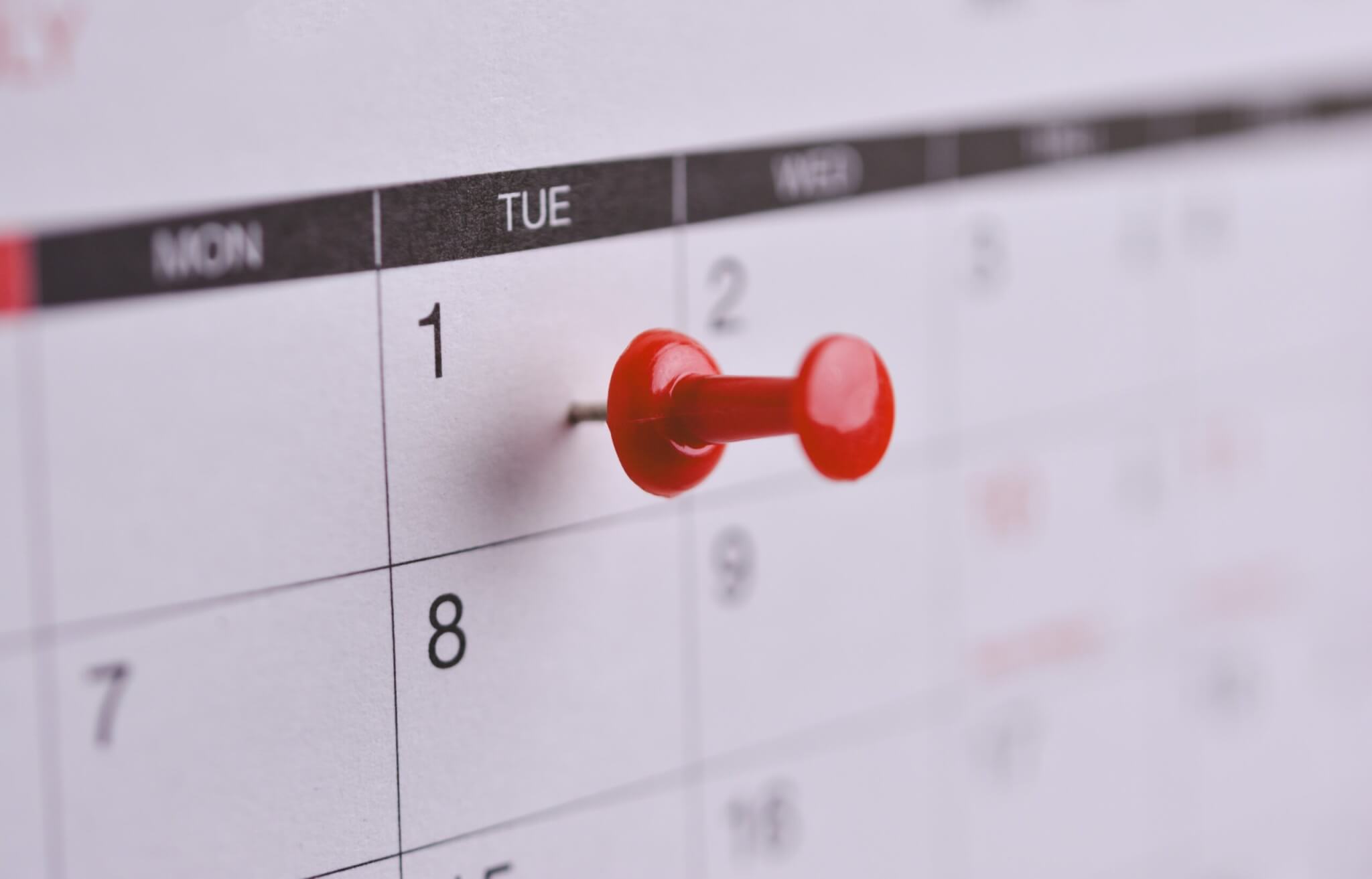 Close-up of calendar pin, first day of month, travel planning.