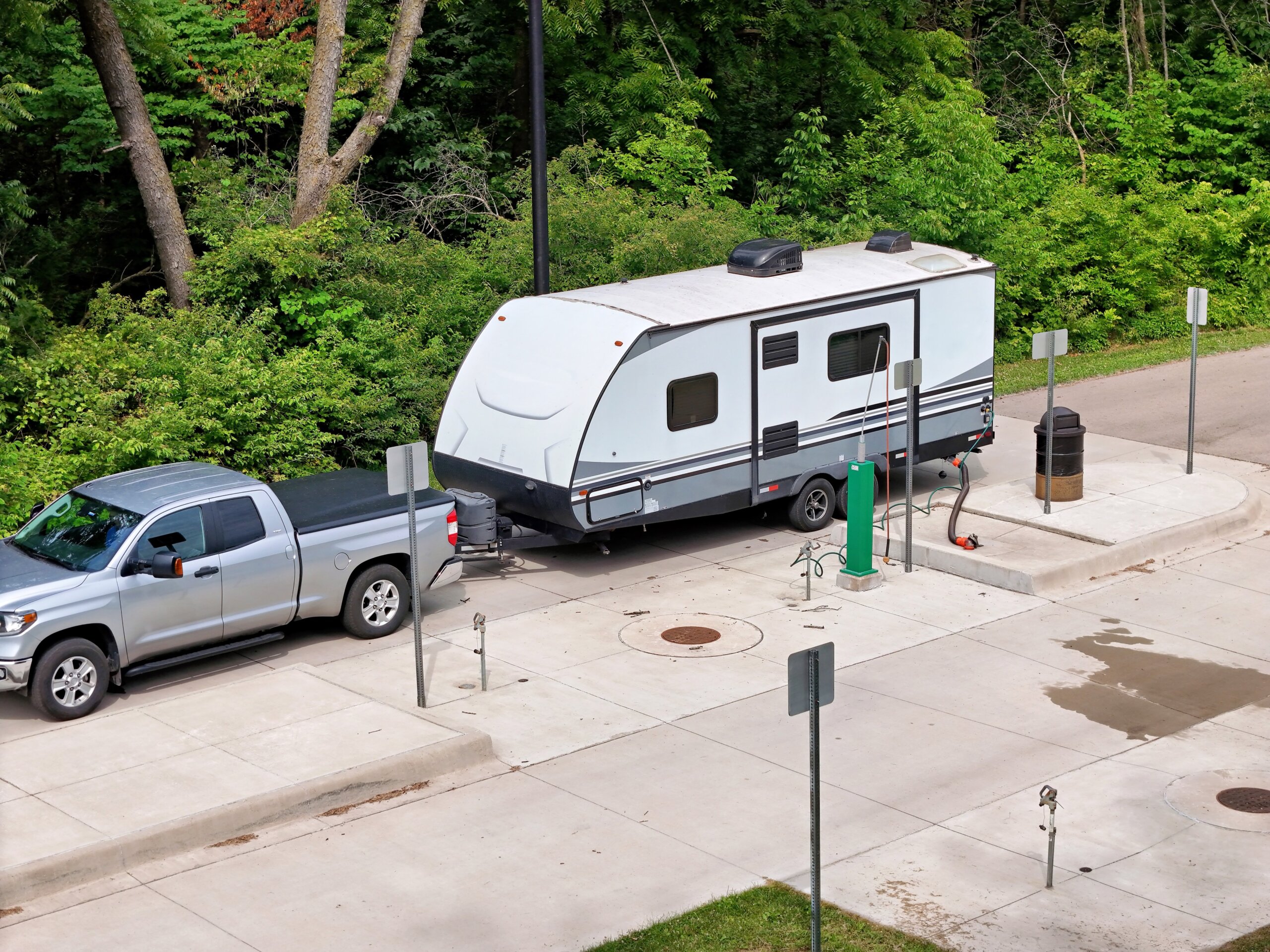 Travel trailer RV camper emptying waste tanks at a dump station
