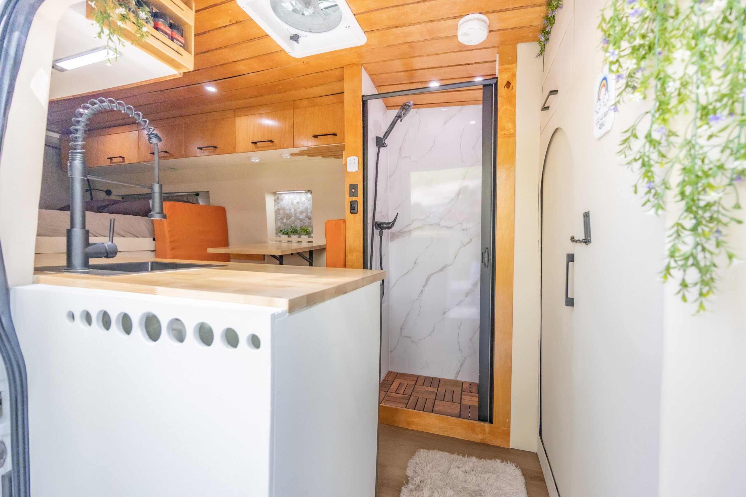 Interior view of an RV with a warm and cozy design, featuring wooden accents and soft lighting for a homey atmosphere.