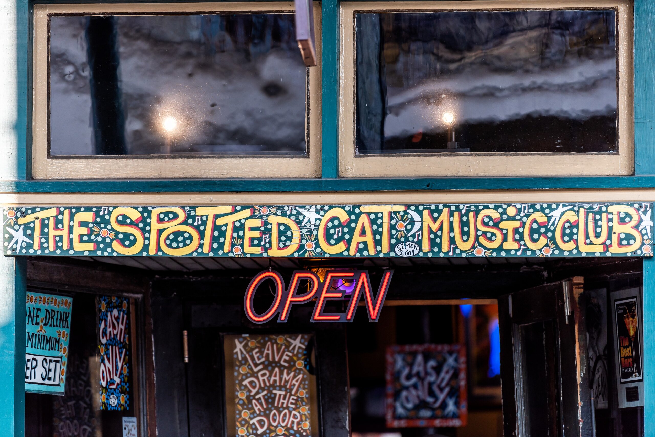 Close-up of the Spotted Cat Music Club sign on Frenchmen Street in New Orleans, a popular local jazz venue known for live performances.