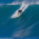 Surfer surfing big ocean barrel tube wave at Pipeline in north s