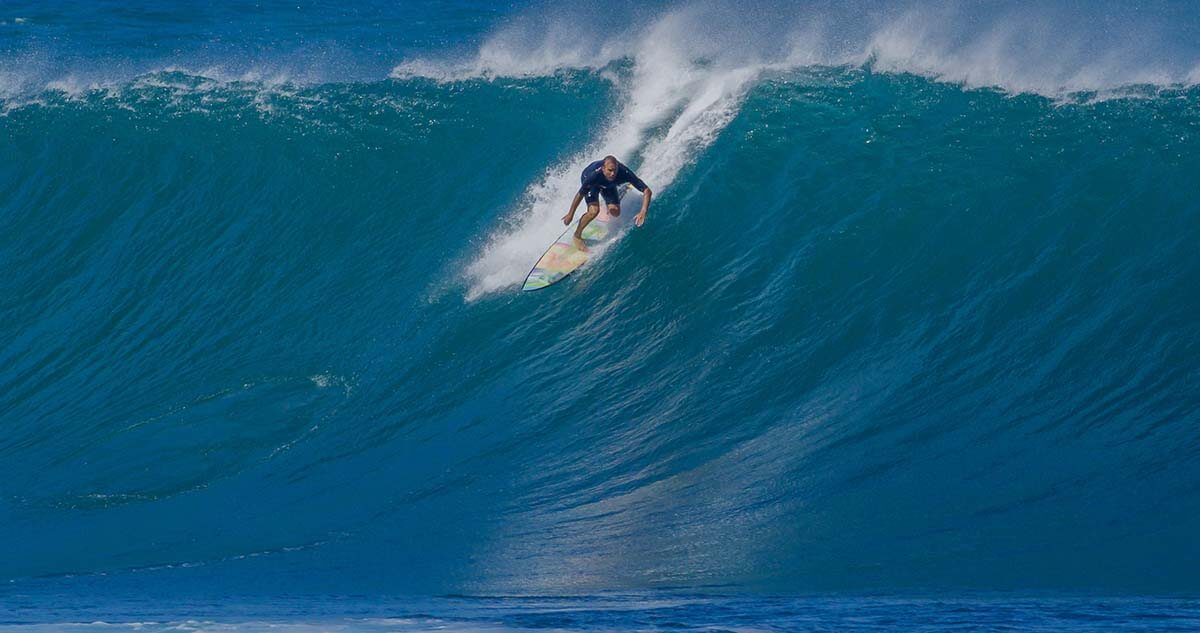 Surfer surfing big ocean barrel tube wave at Pipeline in north s