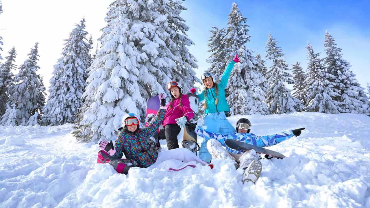 a group of people sitting in the snow with snowboards