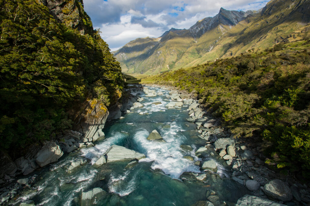 Alpine river flows between rocks at Rob Roy Glacier near Wanaka, New Zealand