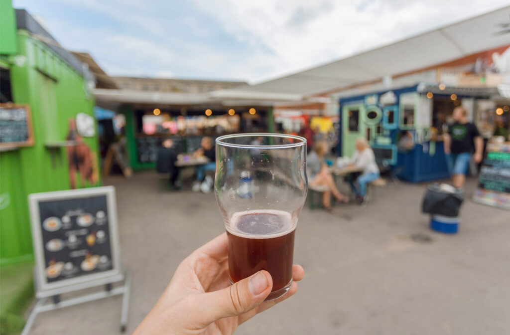 Beer drinkers on street food market of Copenhagen, Denmark. Leisure in Scandinavia with drinks and food of popular city market