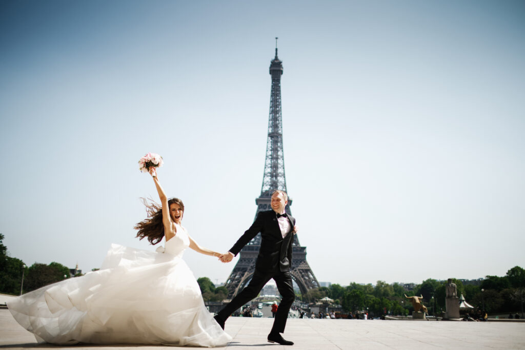 Bride and groom run before the Eiffel tower in Paris