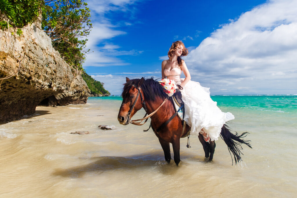 happy bride walking with horse on a tropical beach