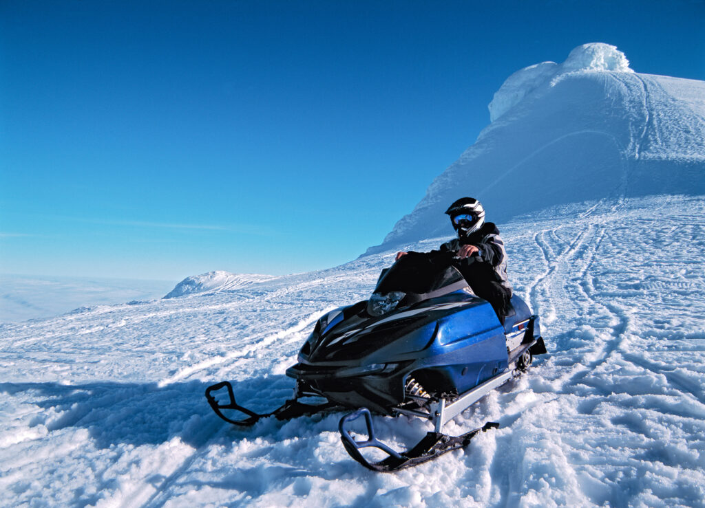 man riding his snow scooter on Snaefellsnesjokull glacier