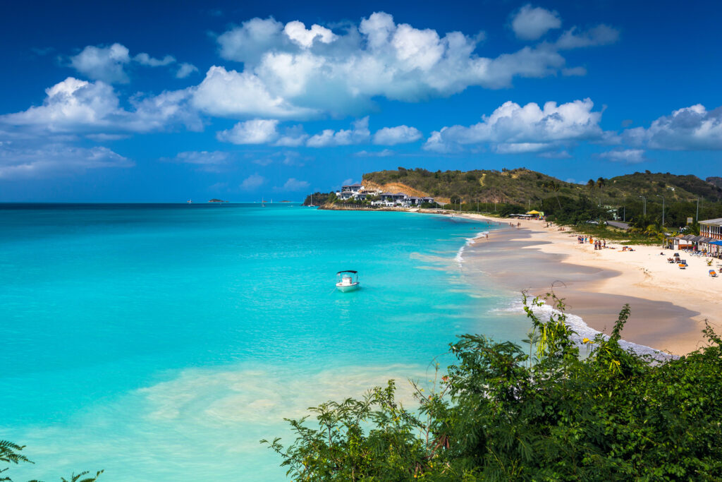 Tropical beach at Antigua island in Caribbean with white sand, turquoise ocean water and blue sky