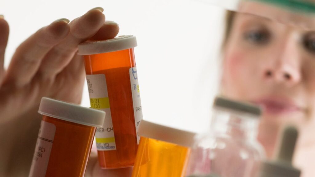 Woman looking through medicine cabinet 