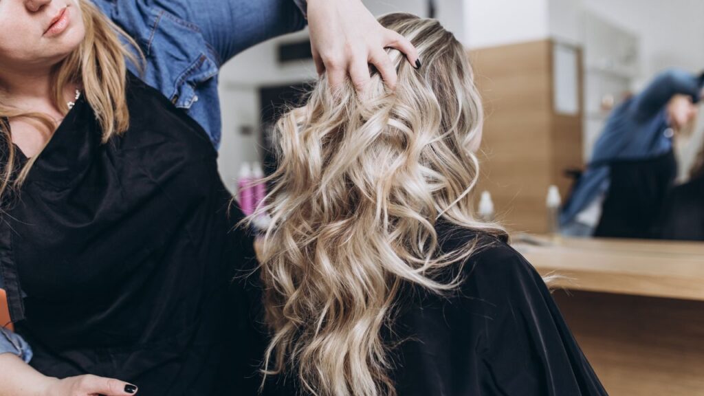 Hairdresser running her fingers through curly hair