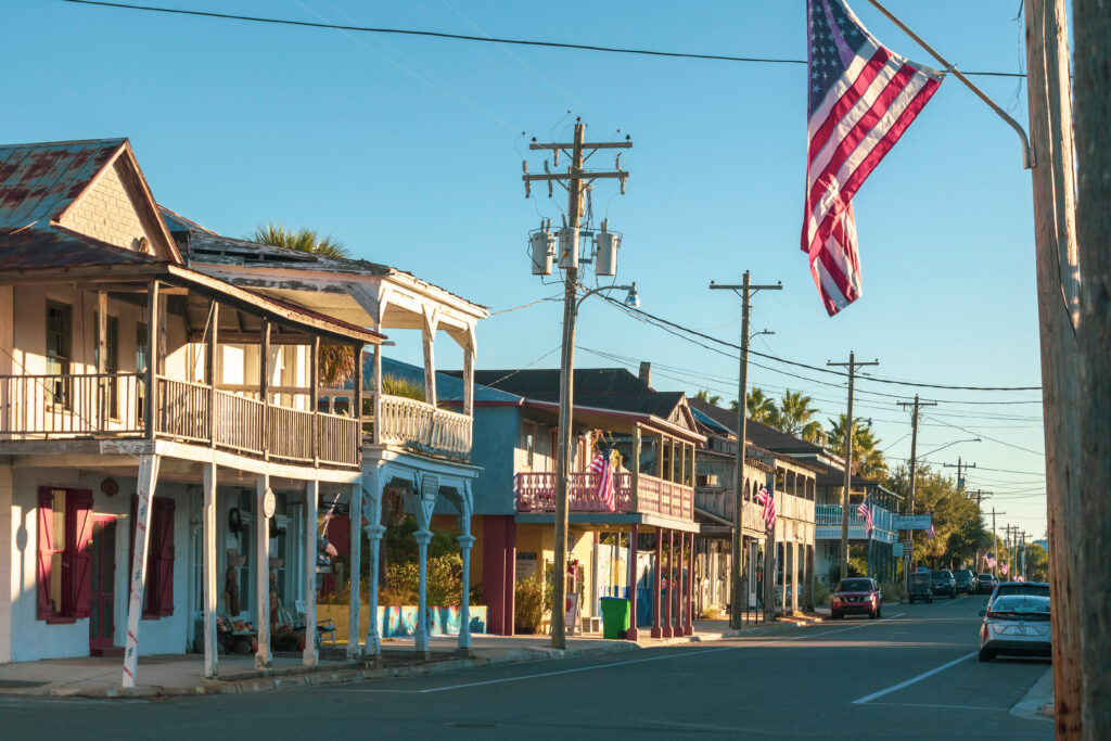 An American flag on a street in historic downtown Cedar Key, Florida in the morning with a blue sky.