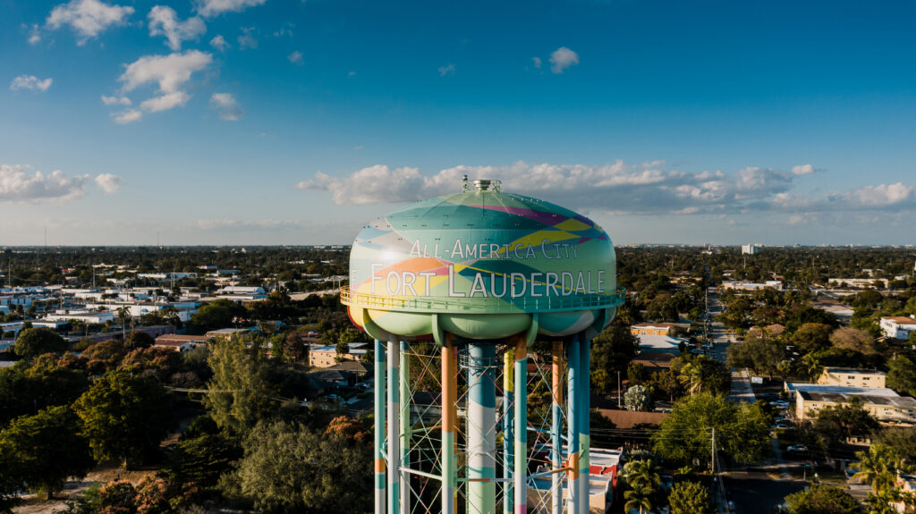 Cityscape with residential buildings between lush trees and tall water tower