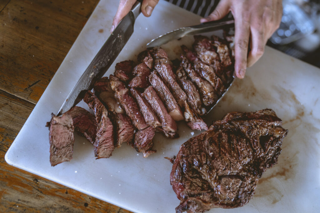 Close up shot of a person slicing cooked meat