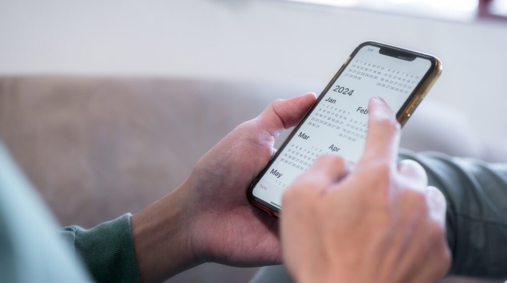 Concept for financial planning and reminder for 2024. man using smartphone working with calendar 2024, business planning marketing and investment