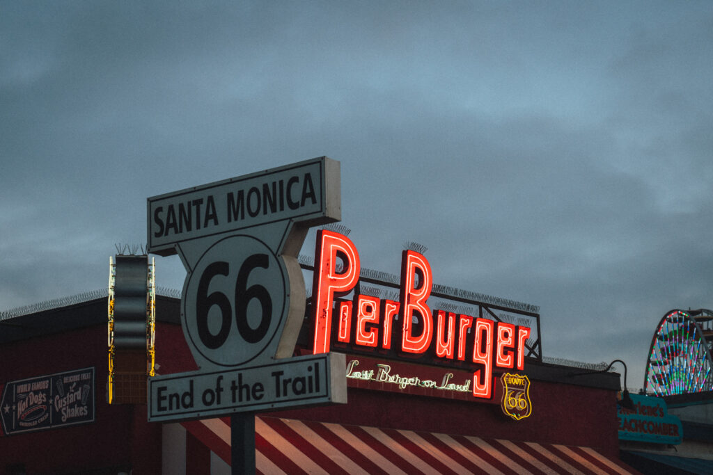 Fast food restaurant and famous road sign against overcast evening sky