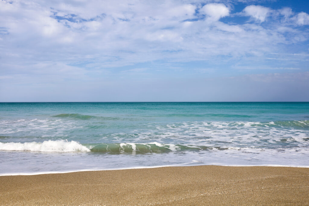 Sunny day in Fort Pierce, Florida on North Hutchinson Island beach along Atlantic Ocean. Uncrowded and pristine beaches of the Treasure Coast St. Lucie County, FL. Greeting from the Sunrise City.