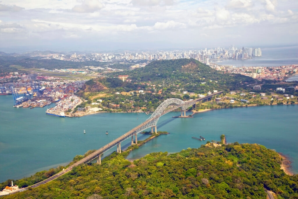 Aerial view of the Bridge of the Americas at the Pacific entrance to the Panama Canal with Panama City in the background.