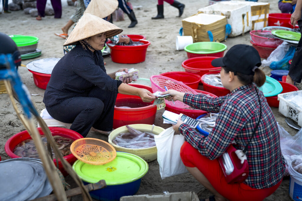 Asian woman selling seafood on street market