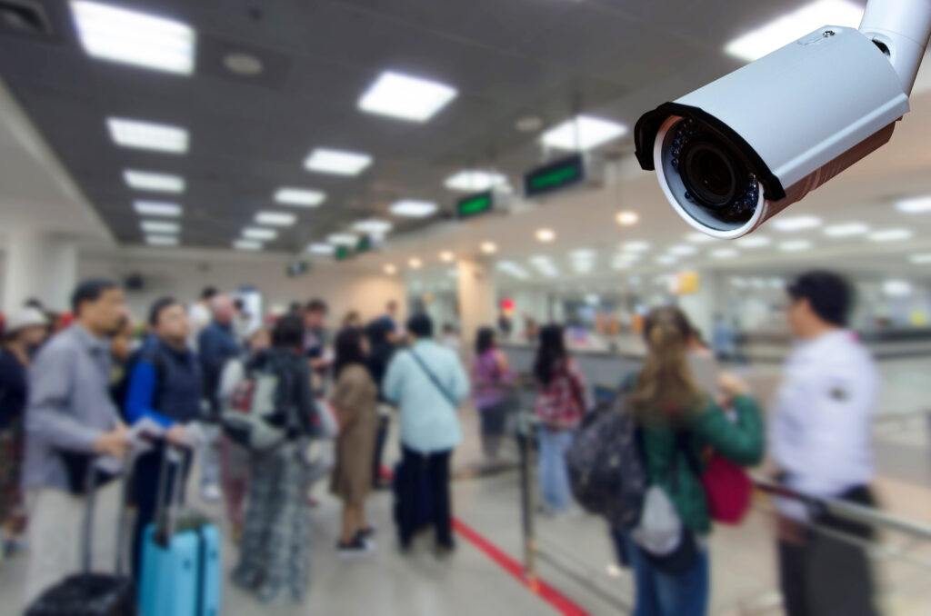 cctv security camera on blurred image of tourist queue at immigration control at airport, security technology concept.