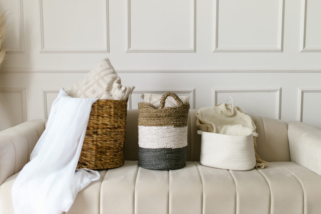 Clothing items inside woven baskets on a sofa