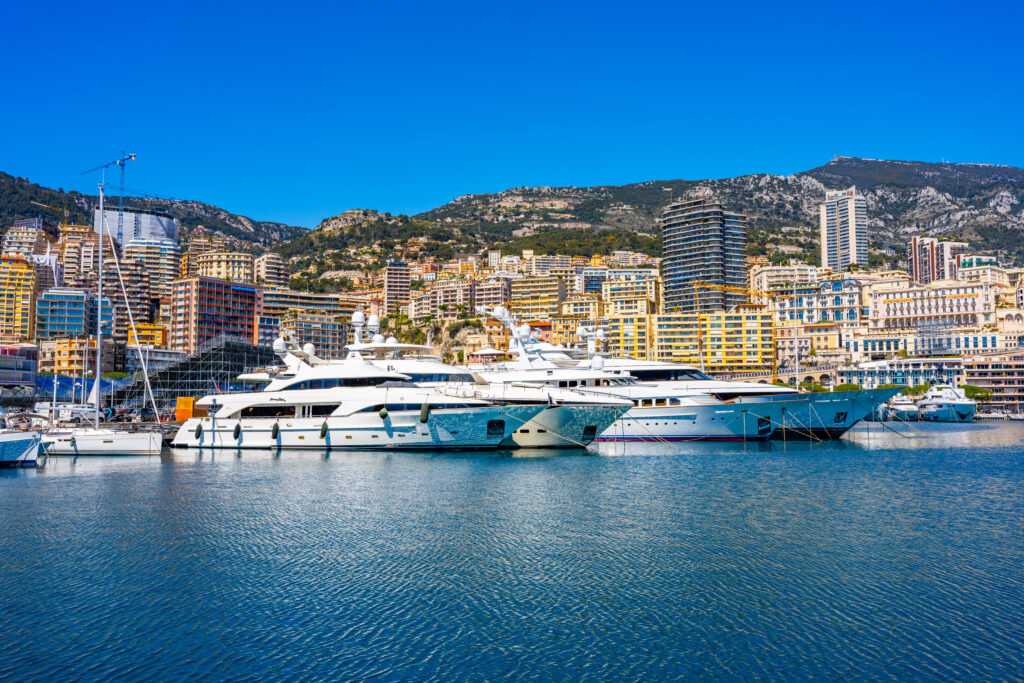 Monaco, Monaco - April 5 2022 - Big yachts in the port Hercule harbour with in the background the old city
