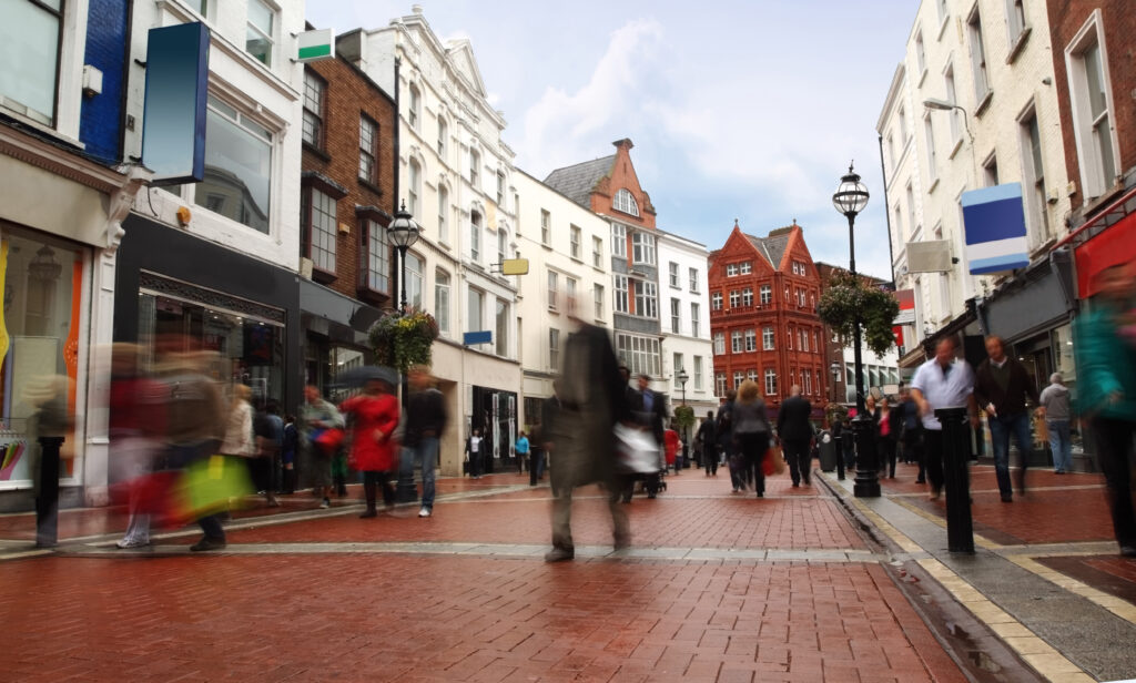 people quickly going on small, narrow street in cloudy weather