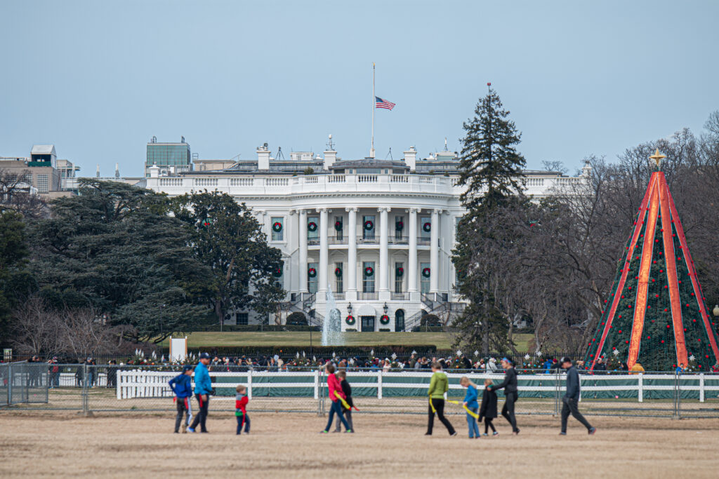 People walking near a white building