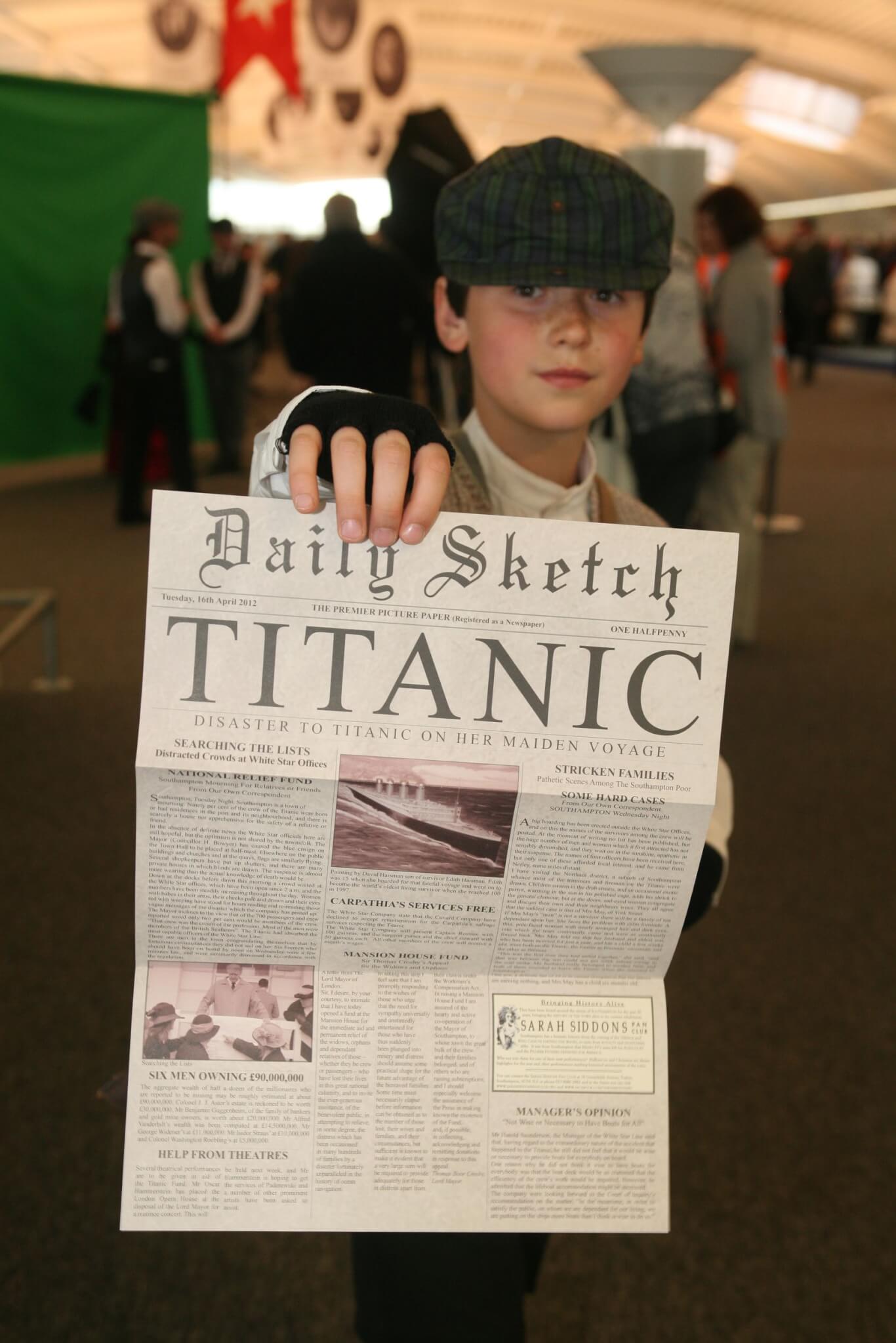 A boy in period costume handing out memorial newspaper in the departure lounge