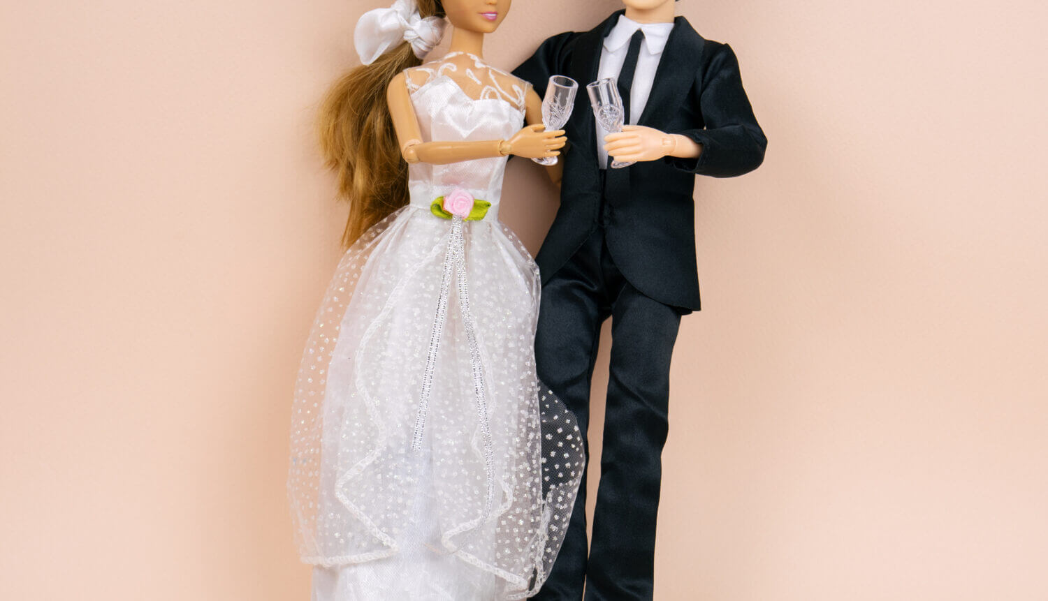 wedding dolls bride and groom with wine glasses on a beige background