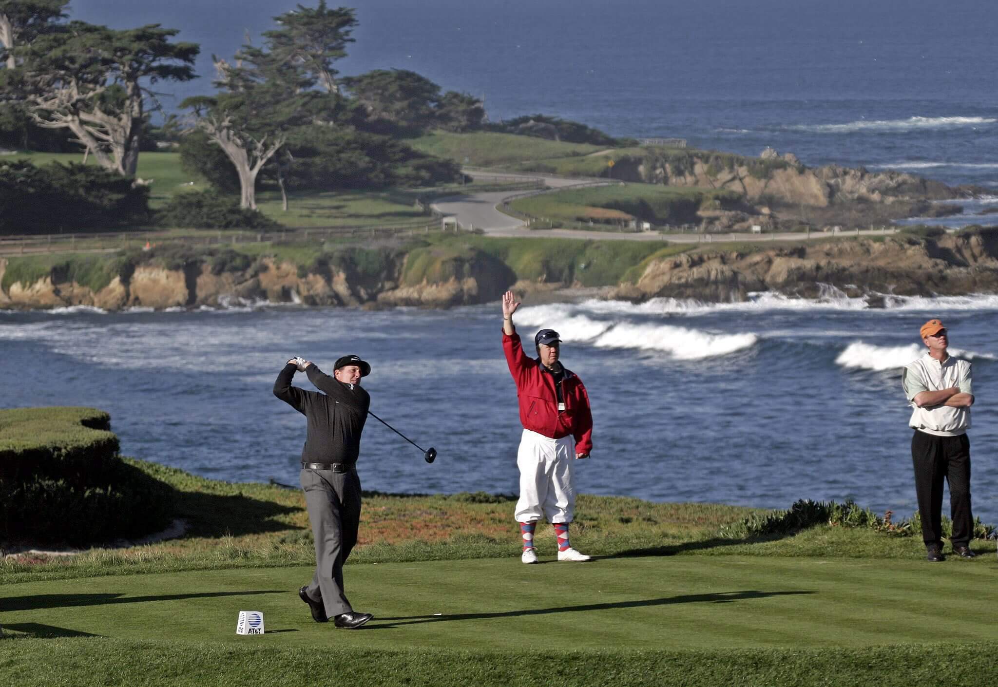 Cypress Point Provides the Background As Phil Mickelson Tees-off On the 4th Hole at Spyglass Hill Golf Course During the First Round of the Pebble Beach National Pro-am in Pebble Beach California Thursday 10 February 2005 Standing at Right is Mickelson's Amateur Partner Steve Lyons