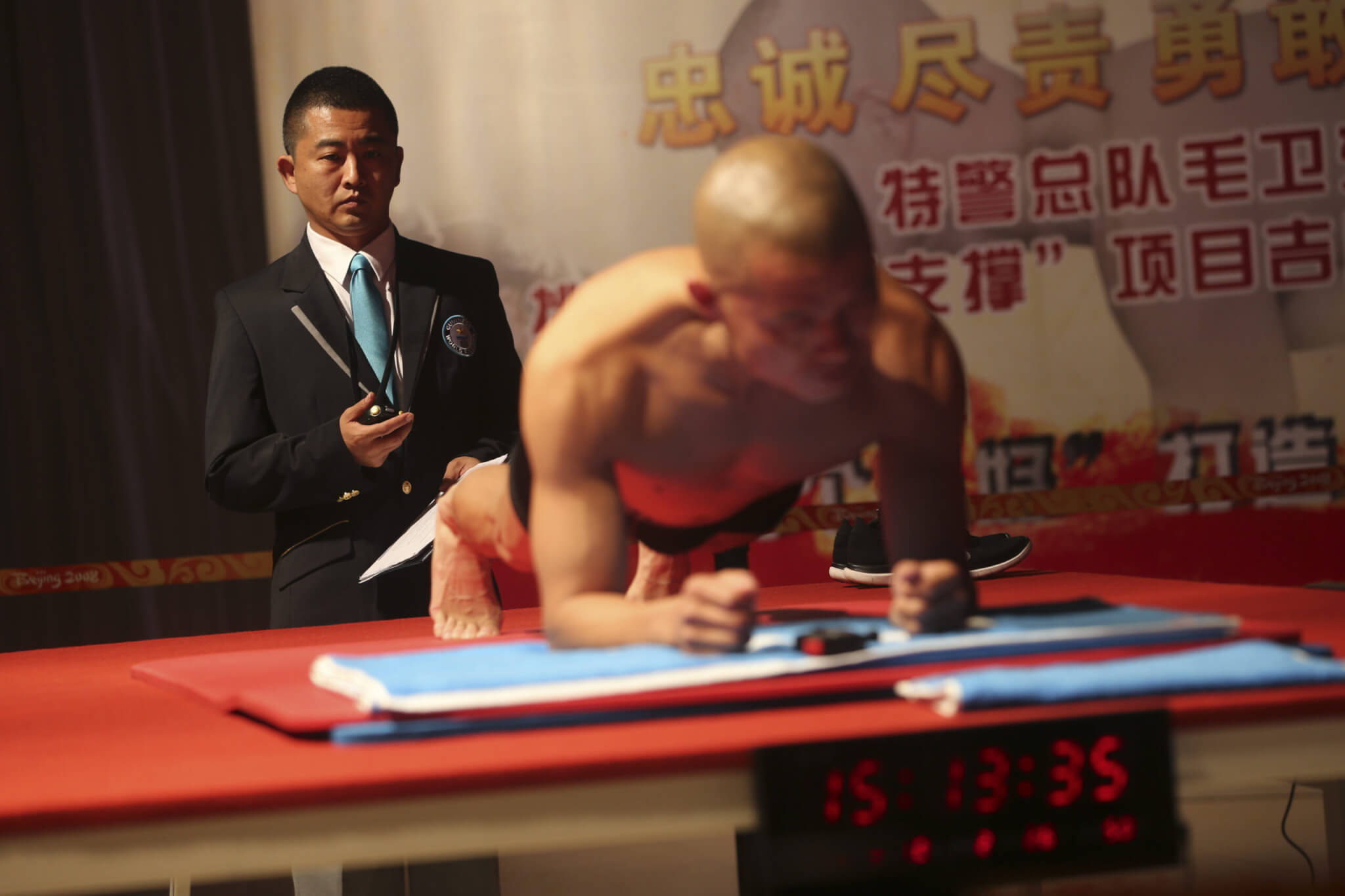 An Official Time Keeper For Guinness World Records Observes Chinese Police Officer Mao Weidong in Plank Position During His Guinness World Record Attempt at the Longest Time in Abdominal Plank Position in Beijing China 26 September 2014 Mao Weidong Broke the Previous Record of 3 Hours 07 Minutes by Achieving a New One of 4 Hours 26 Minutes China Beijing