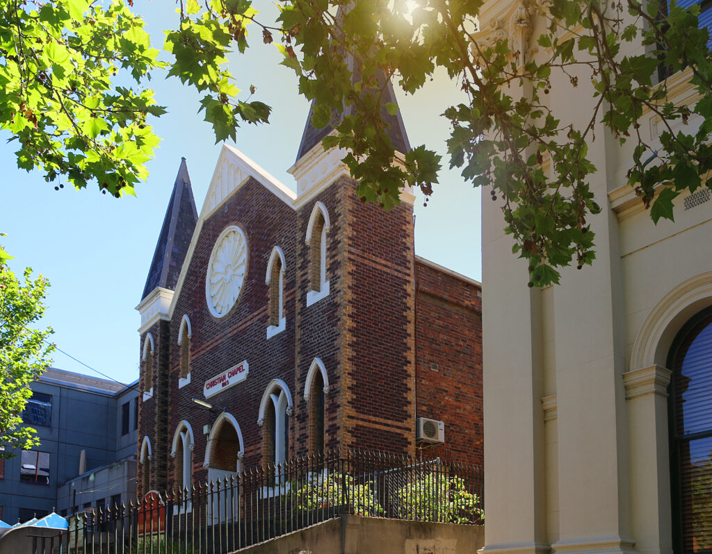 Sunny view through leaves at the Lygon Street Christian Chapel in Melbourne built in 1865 (Victoria, Australia)