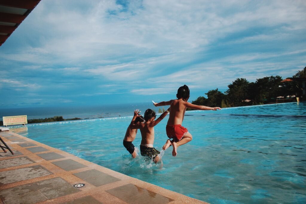 Three boy s jumping into the water