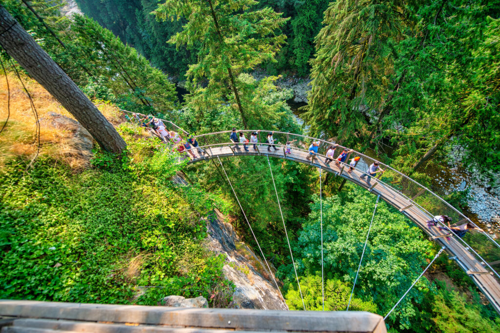 Vancouver, Canada - August 11, 2017: People at Capilano Bridge. It is a Suspension bridge crossing the Capilano River, 140 metres long and 70 metres above the river.