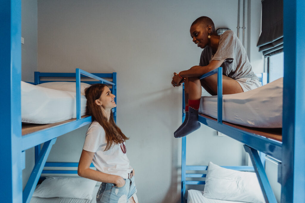 Women talking in a hostel room with bunk beds