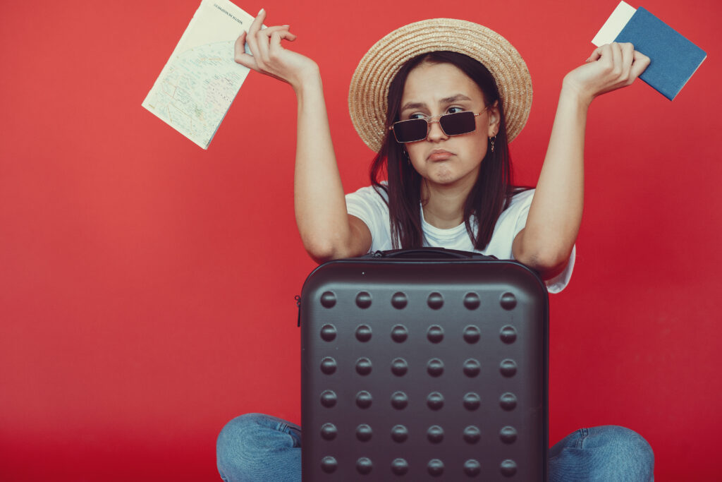 Anxious young lady with tickets and passport on red background