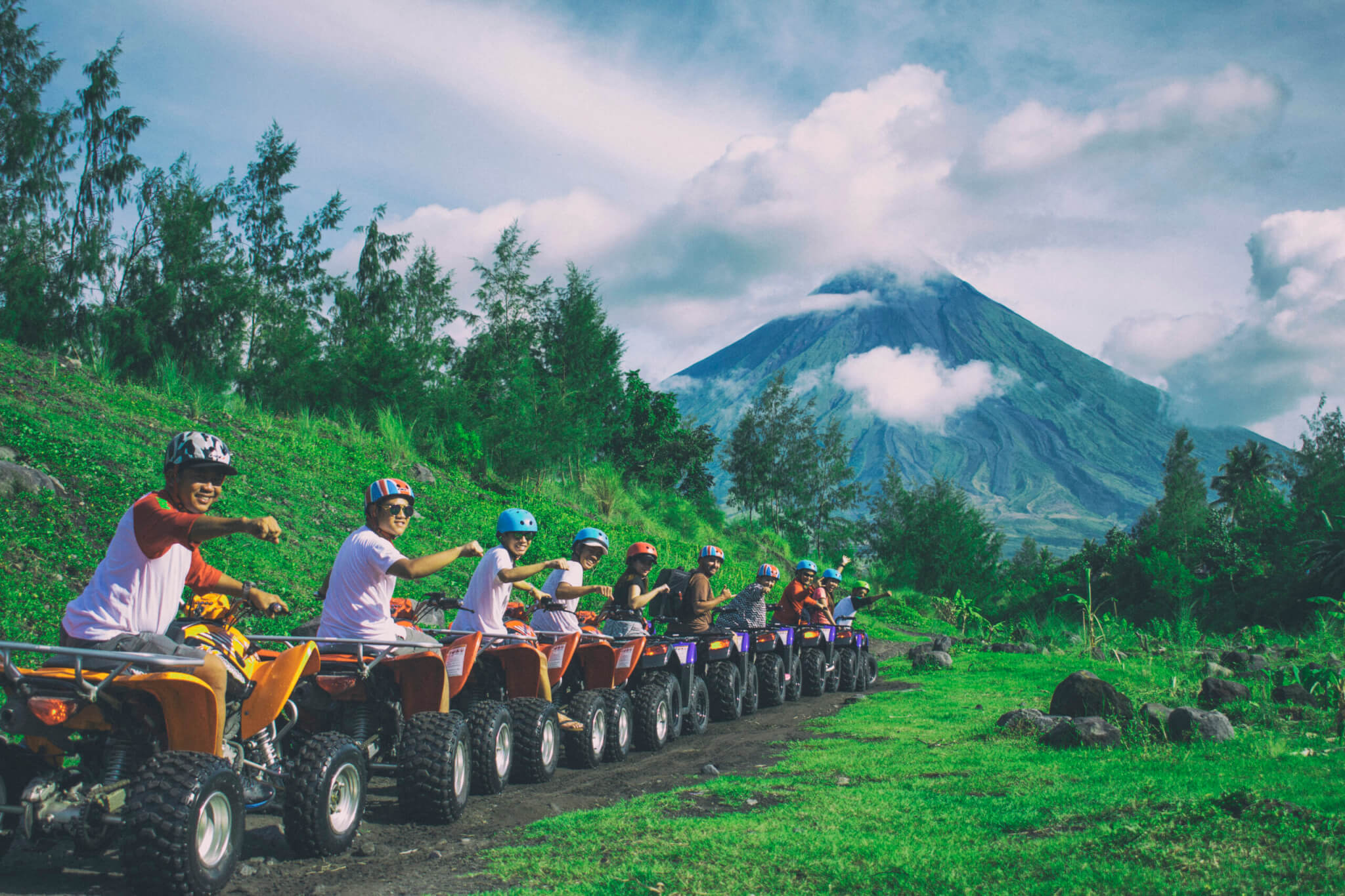 Line of men riding on all terrain vehicles holding out hand in a fist