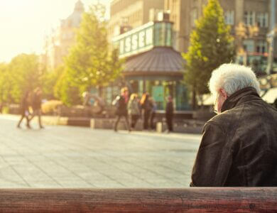 Man sitting on wooden bench wearing black leather jacket