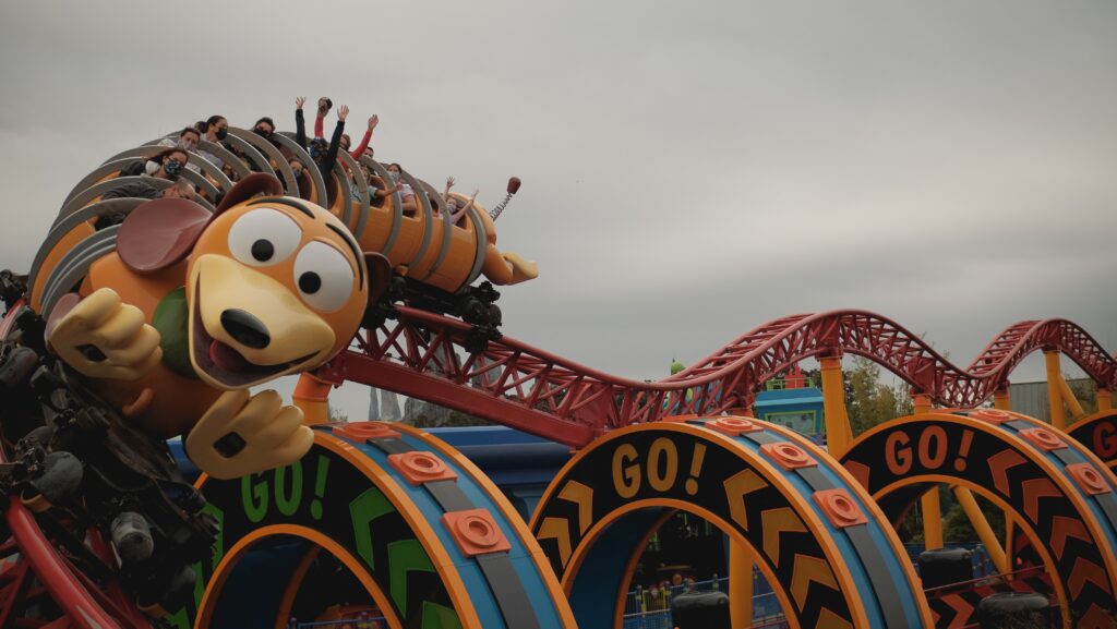 mickey mouse riding on red and blue roller coaster