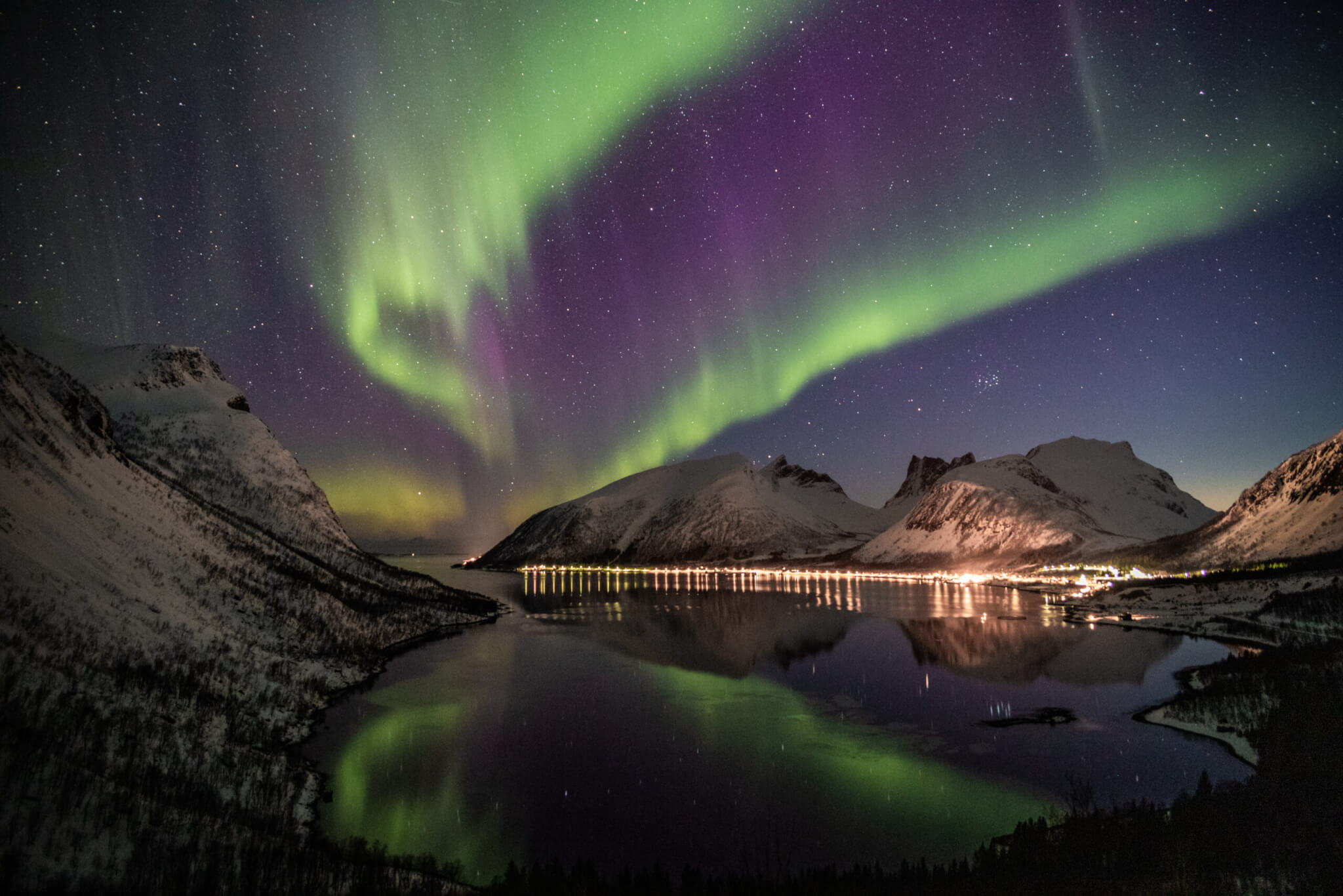 Northern lights near snow coated mountains