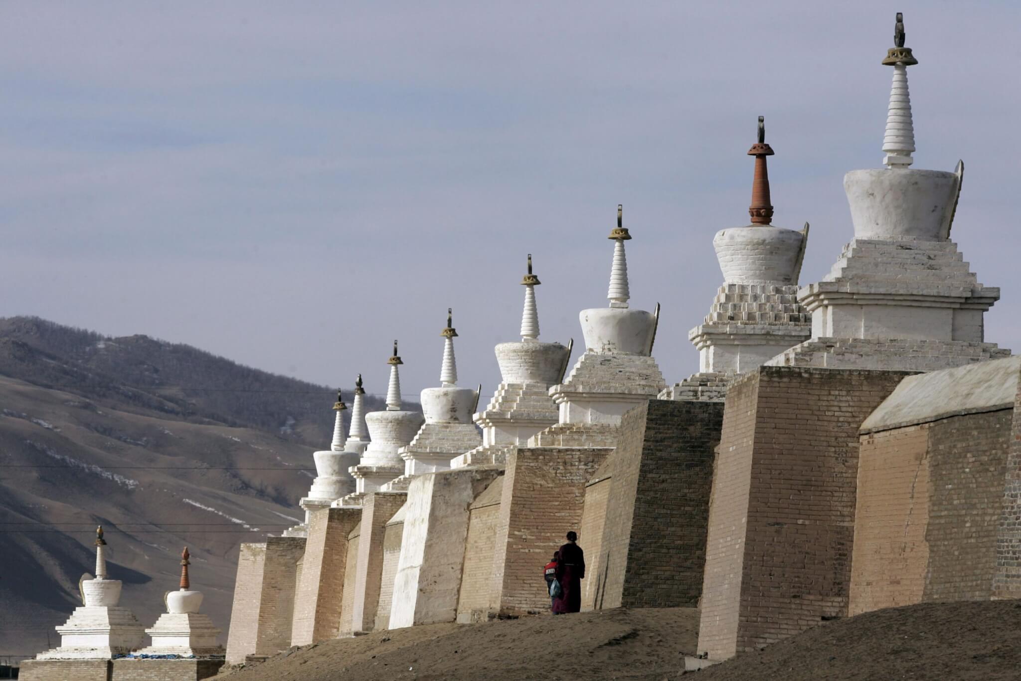 Mongolian Pilgrims Walk at the Base of Some of the 108 Stupas at the Erdene Zuu Monastery Mongolia's 16th Century Monastery of the Yellow Hat Sect of Buddhism Currently Maintained by 60 Monks in Karakorum Mongolia Saturday 04 February 2006 the Monastery Was Built On the Site of Chingis (genghis) Khan's Capital City Karakorum About Three Centuries After the City Was Destroyed by Manchurian Soldiers in the 14th Century Mongolia Celebrates It's Historical Heritage During 2006 As the 800th Anniversary of the Year Clan Leader Temujin Was Officially Proclaimed Chingis Khan and Founded the Great State of Mongolia