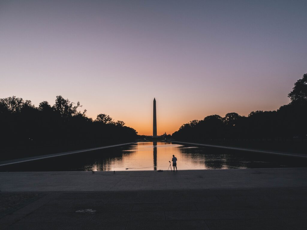 silhouette photo of person standing near body of water