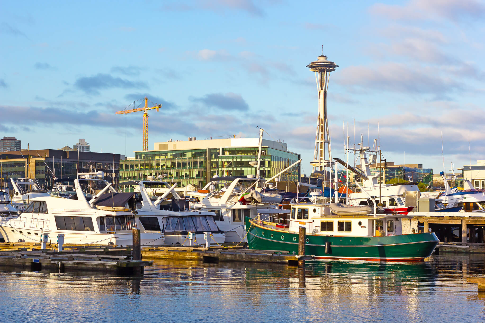 A view on Seattle Space Needle from the waters of Lake Union. A morning in Seattle downtown in the morning with yachts reflections in the lake.