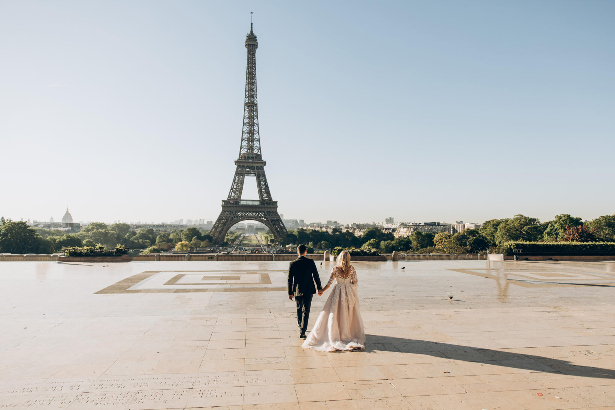 Woman and man walking in park in front of eiffel tower