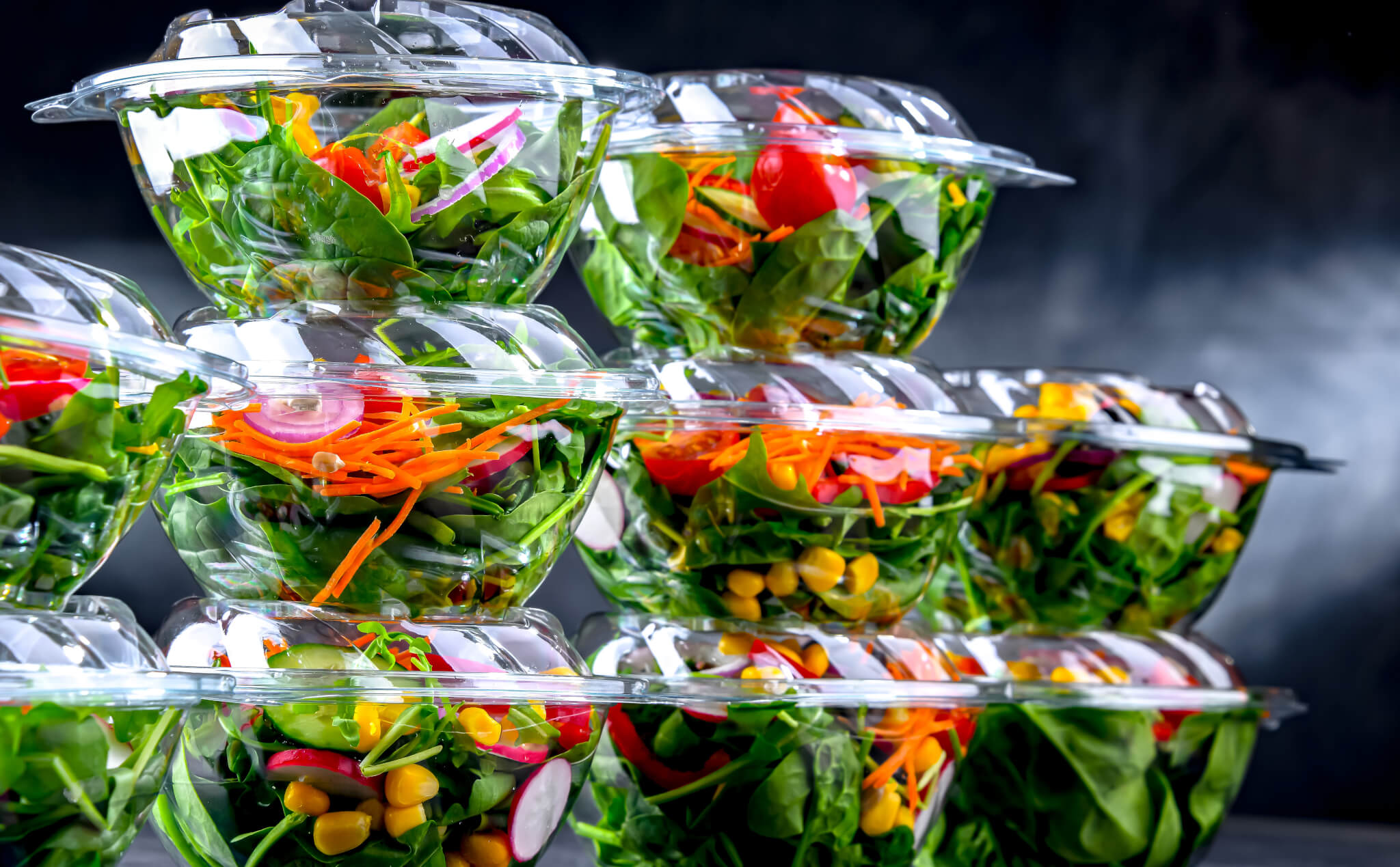 Boxes with pre-packaged vegetable salads in a commercial fridge