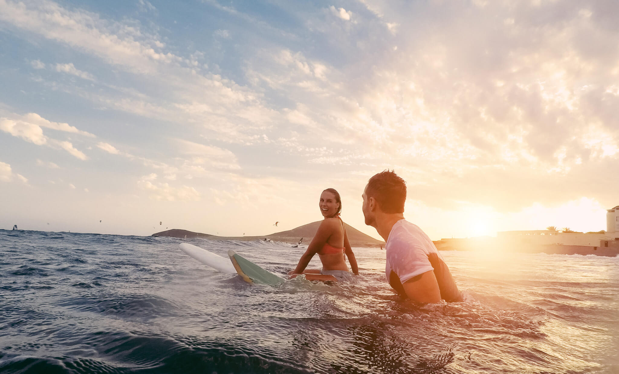 Fit couple surfing at sunset