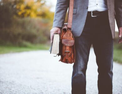 Man with leather bag and book