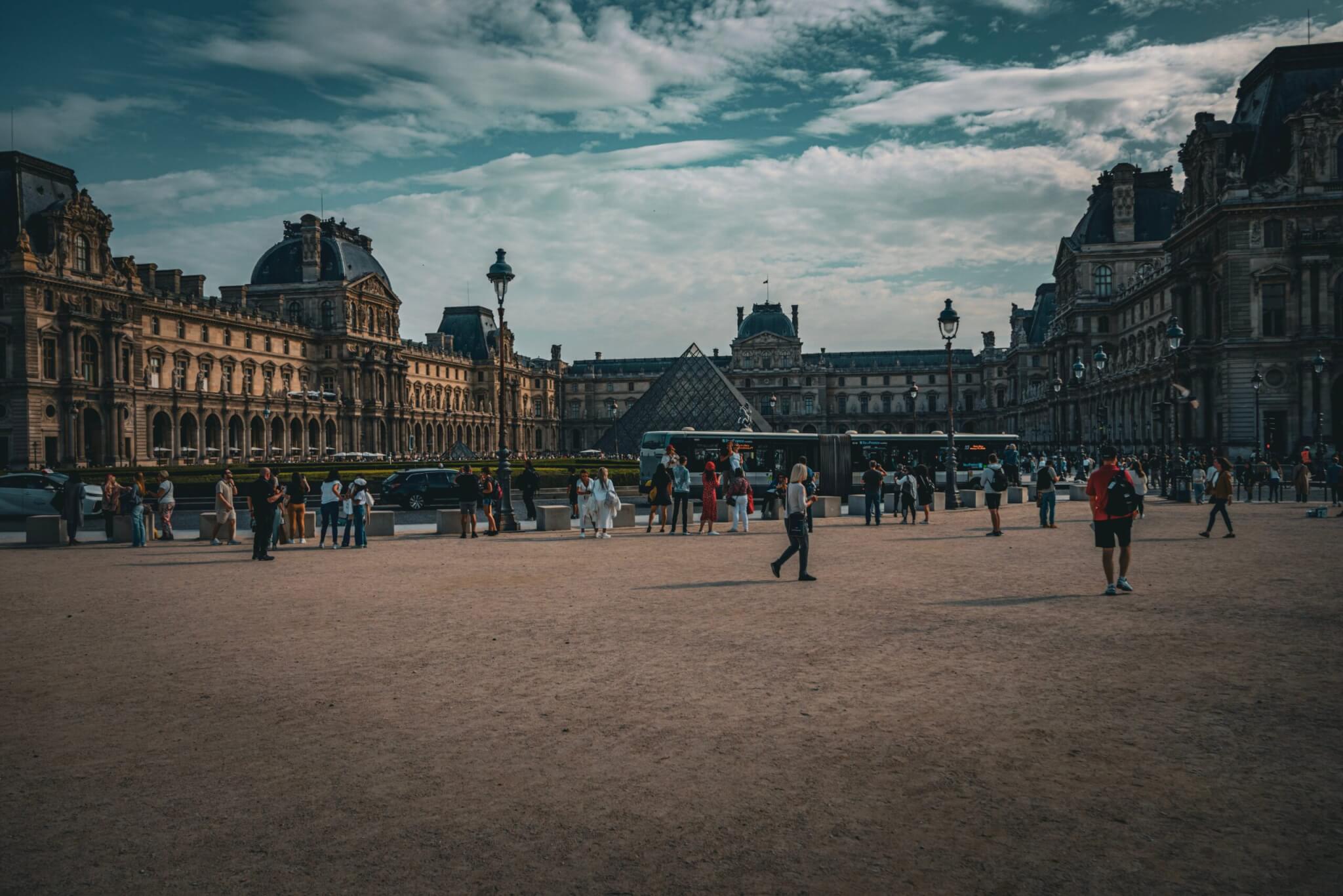 People walking on square near louvre museum